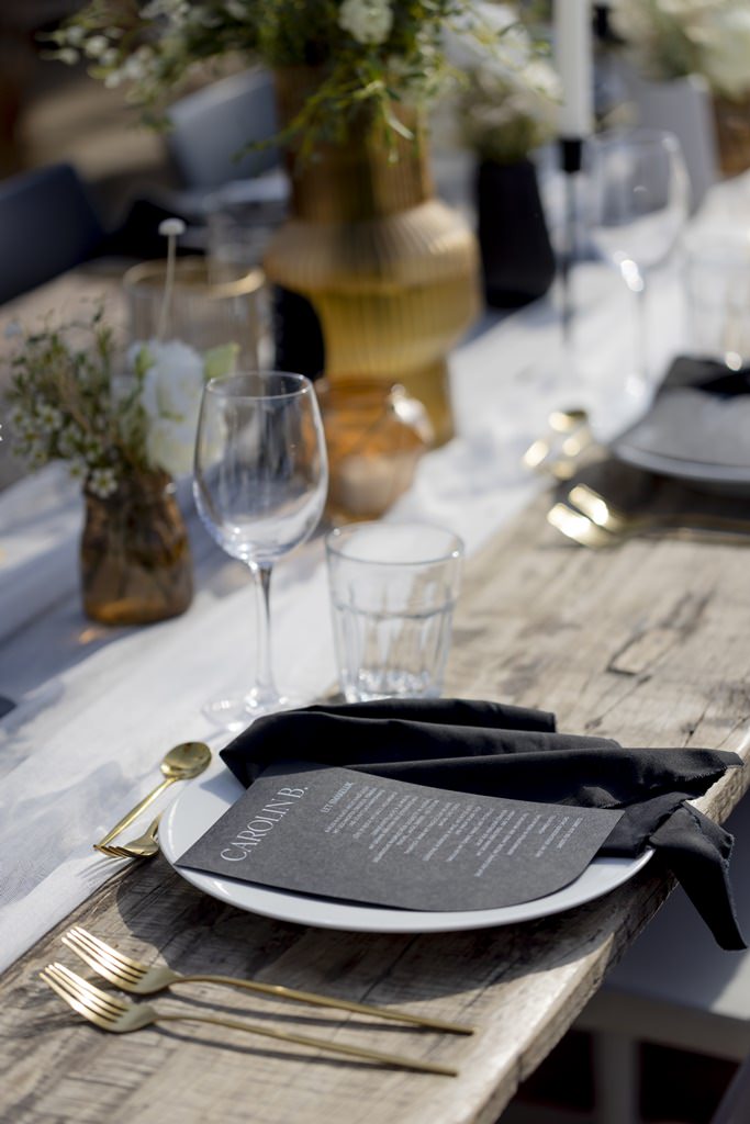 moderne Hochzeitstischdeko mit goldenem Besteck, schwarzer Stoffserviette, schwarzer Menükarte und weißem Teller | Foto: Hanna Witte