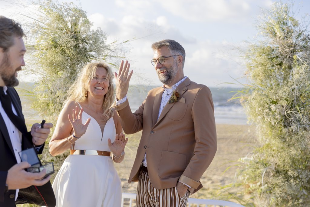 das Brautpaar einer Silberhochzeit mit dem Trauredner während der Erneuerung des Eheversprechens am Strand | Foto: Hanna Witte