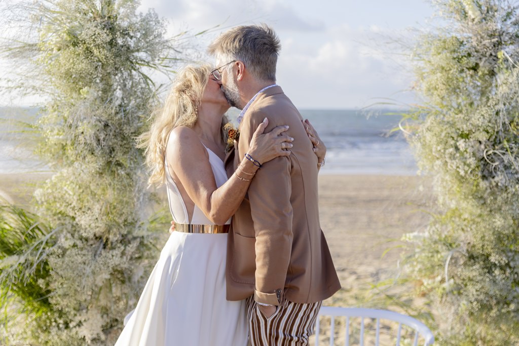 das Brautpaar küsst sich, nachdem es am Strand das Eheversprechen erneuert hat | Foto: Hanna Witte