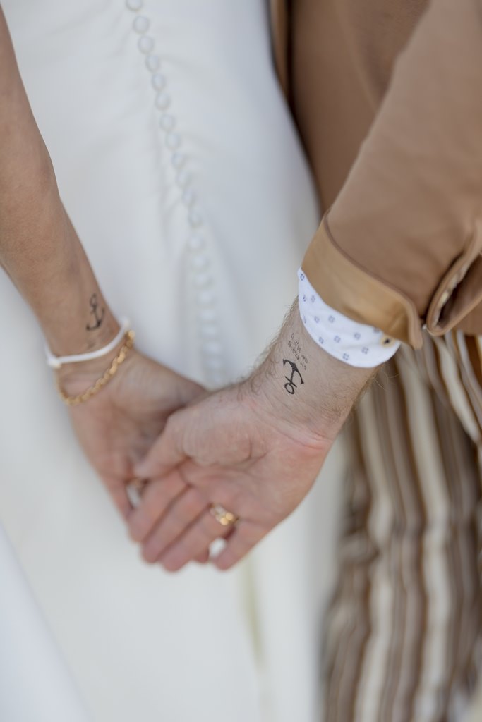 Handgelenke des Brautpaares mit Anker Klebetattoo und Koordinaten der Hochzeitslocation | Foto: Hanna Witte