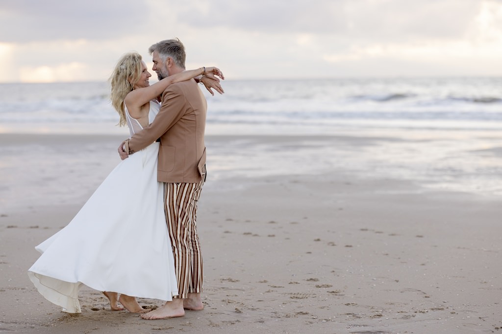 das Brautpaar in inniger Umarmungam Strand mit dem Meer im Hintergrund | Foto: Hanna Witte