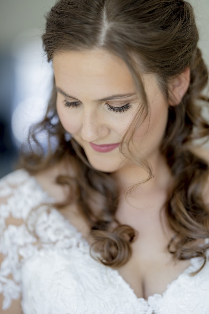 natürliches Halbkörper Brautportrait, bei dem die Braut nach unten und nicht in die Kamera schaut | Hochzeitsfoto: Hanna Witte