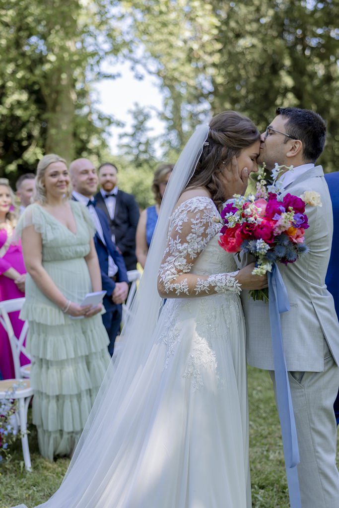der Bräutigam küsst die Braut nach ihrer Ankunft auf die Stirn | Hochzeitsfoto: Hanna Witte