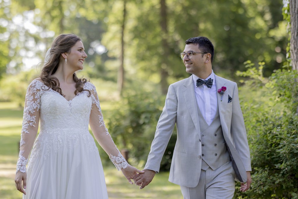Hochzeitsfotopose: Braut und Bräutigam laufen Hand in Hand auf die Kamera zu | Hochzeitsfoto: Hanna Witte