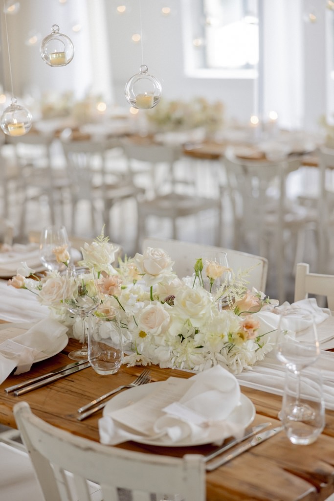Hochzeits-Tischdeko mit Blumengestecken aus Rosen in weiß und rosa | Foto: Hanna Witte